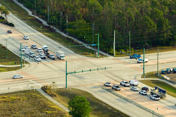 Aerial view of wide multilane road with moving cars at intersection with traffic lights. City...