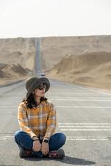 A traveler sits on desert road.