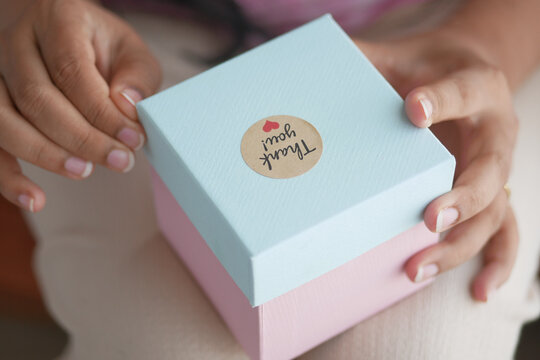 Women Hand Putting A Thank You Sticker On A Gift Box 