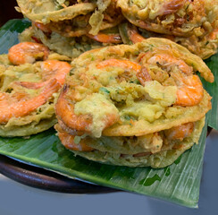 Oily bakwan Udang, fritters snack contains of vegetables and shrimp and mixed with flour dough, high in cholesterol food gorengan Indonesia