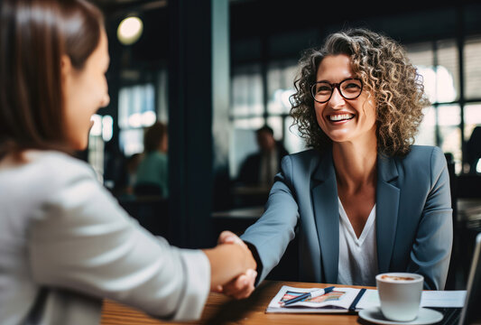 Two women shaking hands at a business meeting