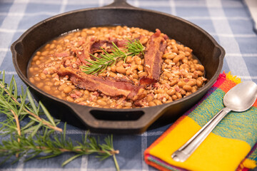 Slow cooked baked beans in cast iron skillet on table