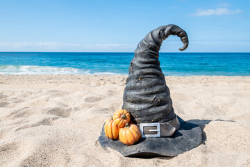 Halloween beach background with witch hat and pumpkins - 653088884