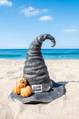 Halloween beach background with witch hat and pumpkins