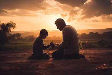 Father and son together praying on knees in beautiful sunset. - obrazy, fototapety, plakaty