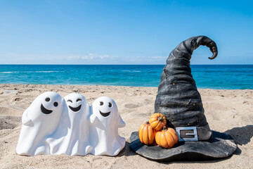 Halloween beach with three ghosts and witch hat background - 653089458