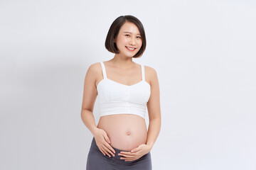 Beautiful asian pregnant woman holding her belly on white background