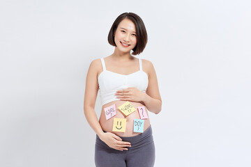 Choosing baby name. Confused pregnant woman with question marks on paper stickers on tummy