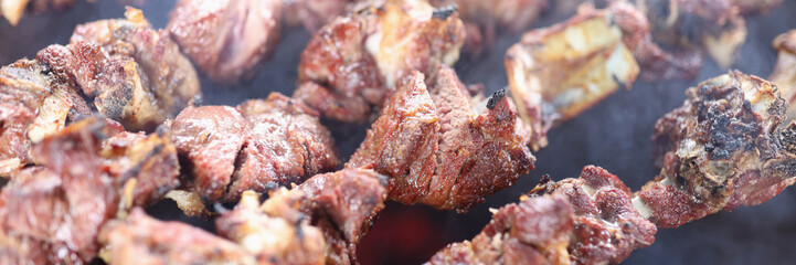 Close up of skewers with juicy meat in smoke.