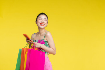 Fototapeta premium Women carrying a lot of colorful shopping bags and mobile phone,Selective focus