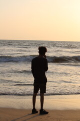man walking on the beach at sunset