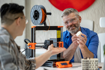Architects making house model using 3D printer, FDM technology for architectural use.