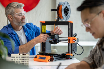 Architects making house model using 3D printer, FDM technology for architectural use.