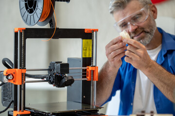 Technician printing in 3d printer, using three dimensional printing machine for work.