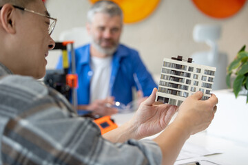 Architects making house model working with 3D printer, creating process.