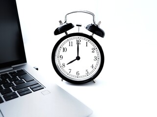 laptop and alarm clock on a white background and copy space 