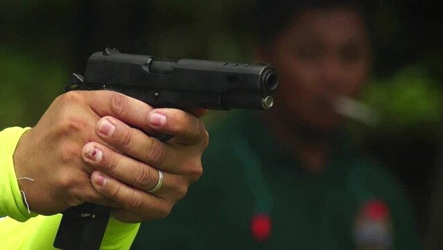 Gun firing practice and exercise by a male shooter. Close-up.