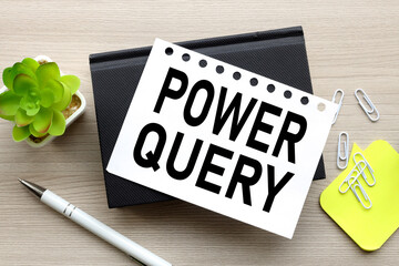 the words Power Query. on a white page on a black notepad