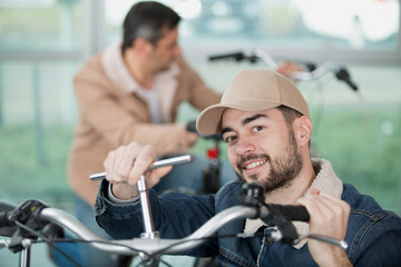 man adjusting handlebars using a socket wrench