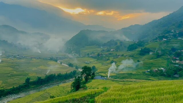 Mu Can Chai, harvesting rice terrace fields landscape with fire smoke on horizon near Sapa, Northern Vietnam