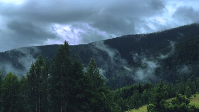 Clouds in the highlands. Vegetation in the mountains. Bad weather for mountain travel. Video of morning fog in the mountains. The livestock farm is located under the mountain.