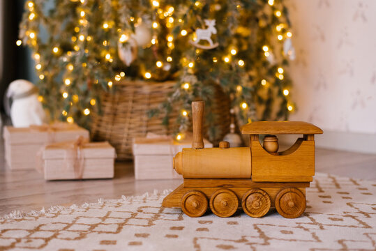 Wooden toy locomotive on the background of a Christmas tree in the children's room
