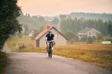 young male cyclist with his gravel bike riding in the countryside, front view. concept of active sports and a healthy lifestyle.