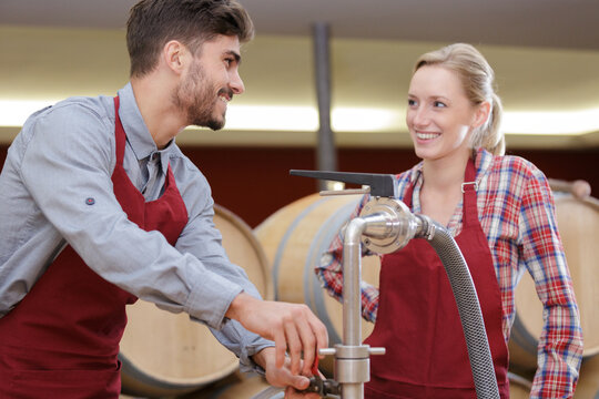 man and woman working in a wine cellar