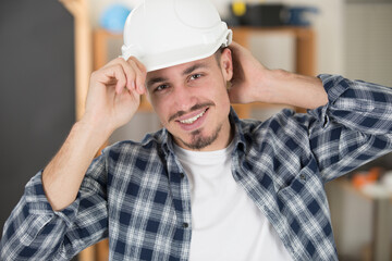 builder in a helmet puts on helmet