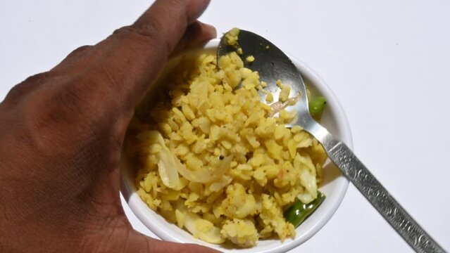 Vegetable Poha in India. It is made by mixing vegetables, poha and spices. Rice is parboiled before flattening so that it can be consumed with very little to no cooking. Indian breakfast.
