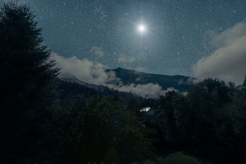 a Christmas star shines at night over the mountains of Bethlehem