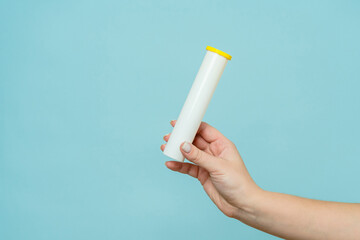 Tube for vitamins, pills in hand. Packaging. Mockup