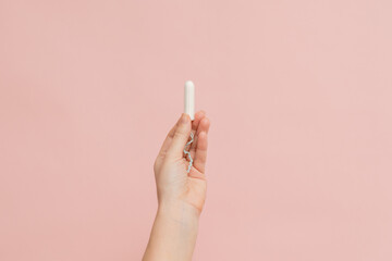 Hand holding medical feminine tampon. Cotton swab. Menstruation