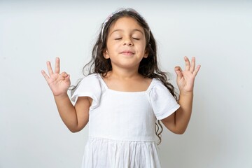 beautiful kid girl wearing dress relax and smiling with eyes closed doing meditation gesture with fingers. Yoga concept.