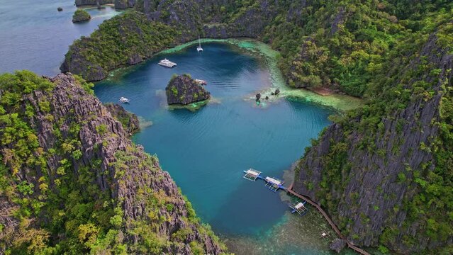 Drone Footage at Kayangan Lake in Philippines. Bird eye view of lagoon and entrance to the lake. We see boats arriving in a beautiful decor