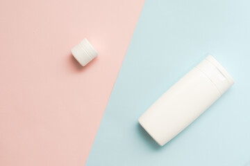 Flat lay of cosmetic bottles and tubes on two colored background