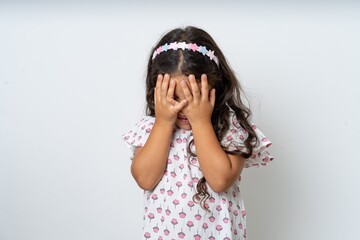 Sad beautiful kid girl wearing dress crying covering her face with her hands. - obrazy, fototapety, plakaty