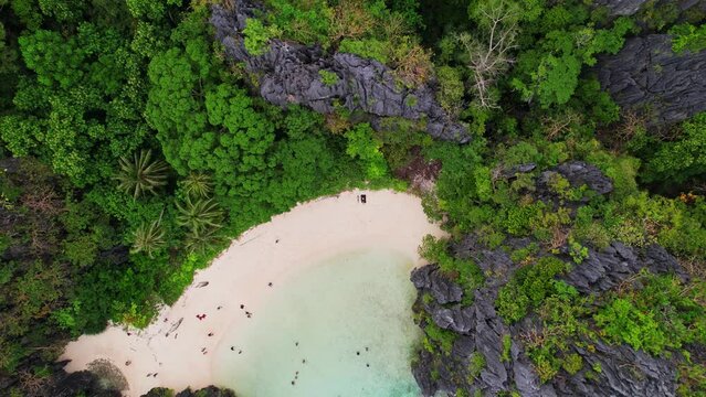 Drone Footage at Hidden Beach in Philippines. Zoom out with camera at 90 degree to see the beach and jungle and rocks and recife.