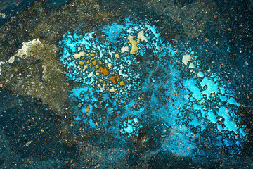 Colored oil stains close-up, color of a gasoline stain on asphalt as a texture or background