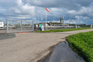 Fototapeta na wymiar Gas installation in Moddergat Friesland. The Nederlandse Aardolie Maatschappij or NAM extracts natural gas from under nature reserve The Wadden Sea.