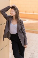 Portrait of a Caucasian attractive and happy young woman in casual clothes in the city while walking on a sunny day. The concept of style, fashion, youth and lifestyle