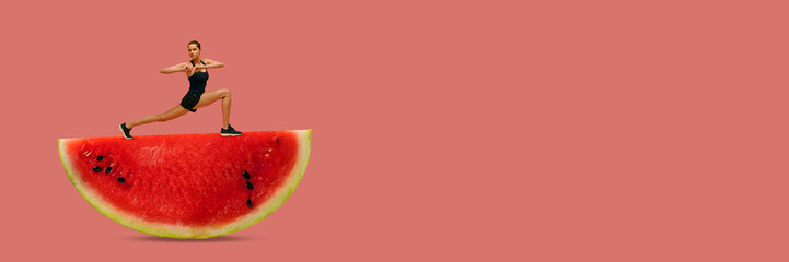 Young woman with beautiful, slim, fit body training over red background, standing on watermelon....