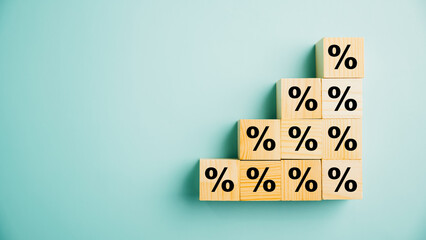 Concept of interest rate and mortgage rates. Hand putting a wooden cube block on top, representing growth and an upward direction, with an accompanying percentage symbol. - obrazy, fototapety, plakaty