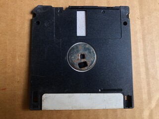 old black diskette in hand