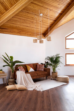 Modern living room with sofa, wooden attic ceiling and big window