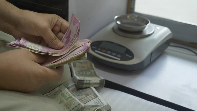 Close up shots of hands counting 2000 Indian rupee banknotes after a transaction