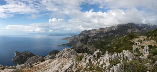 A glued wide angle panoramic photo of coastal landscape of Mediterranean sea at Kalabantia. Amazing seascape of Lycian way: high rock cliffs, mountain ridge, rugged shoreline, blue lagoon. 
