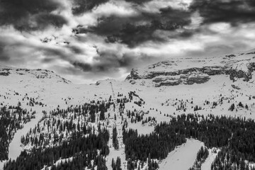 black and white snowy mountain landscape. winter mountain landscape under dramatic sky. ski mountain in the alps in black and white