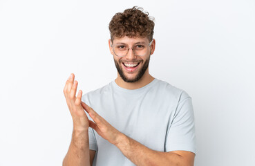 Young handsome caucasian man isolated on white background With glasses and applauding