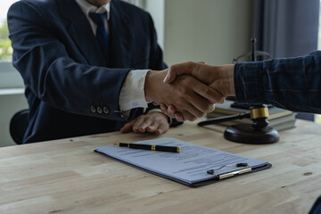Businessman shaking hands to seal a deal with his partner lawyers or attorneys discussing a contract agreement.Shaking hands, Lawyers and clients discuss the rights and liberty of children and women.